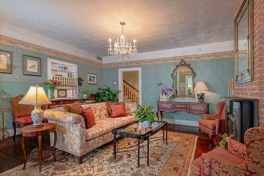 Cozy living room with floral upholstery, a chandelier, and a mix of decorative accents.